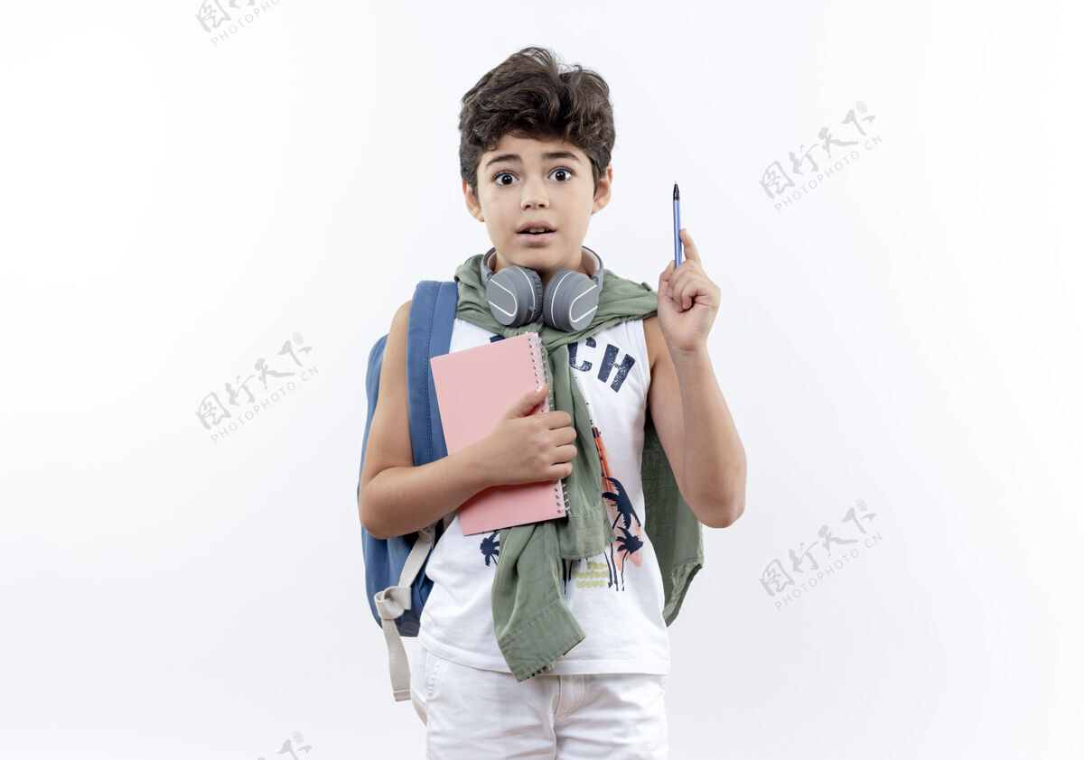 手势惊讶的小男生背着书包 戴着耳机 拿着笔记本 举着笔 孤零零地站在白纸上握着表情小