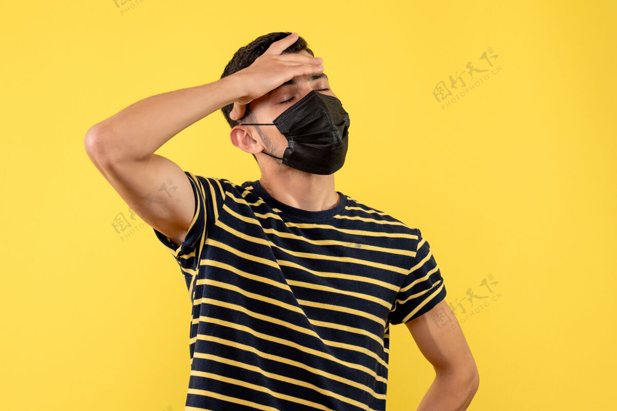 前面前视图身穿黑白条纹t恤的年轻人把手放在黄色背景的额头上成人人手