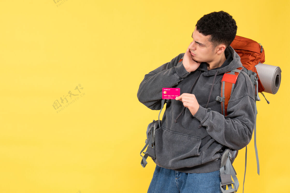 成人前视图困惑的旅行者男子与红色背包举行折扣卡西装人背包