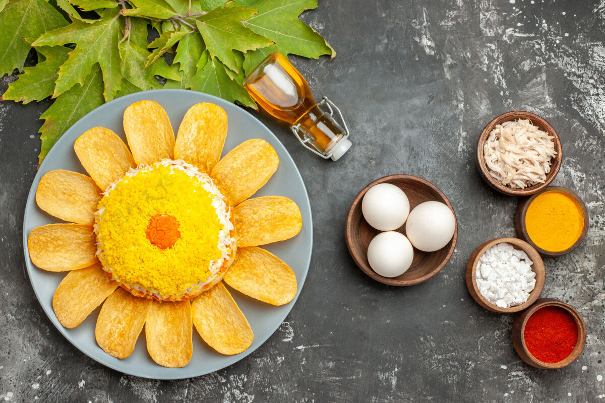 香草在深灰色的桌子上 沙拉的顶视图 旁边放着一碗鸡蛋和叶子 旁边还有香草食物沙拉水果