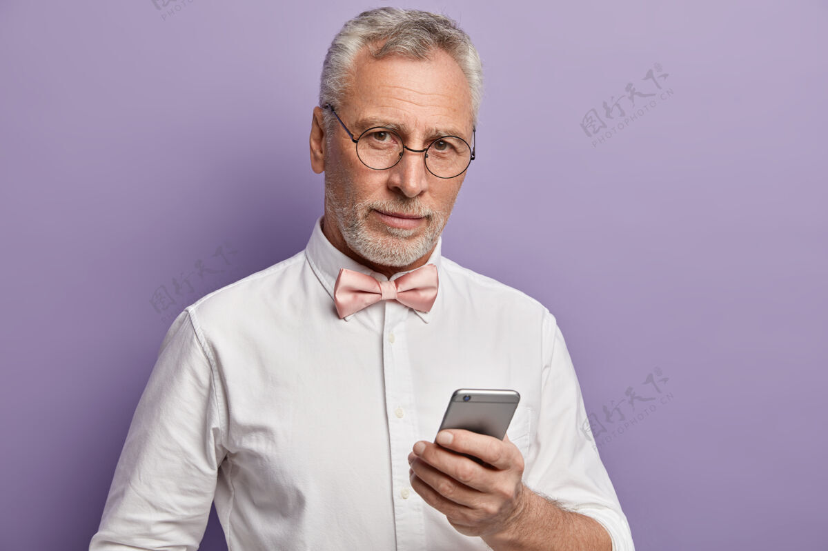 人穿着白衬衫和粉色领结的老人拿着电话领结衬衫男