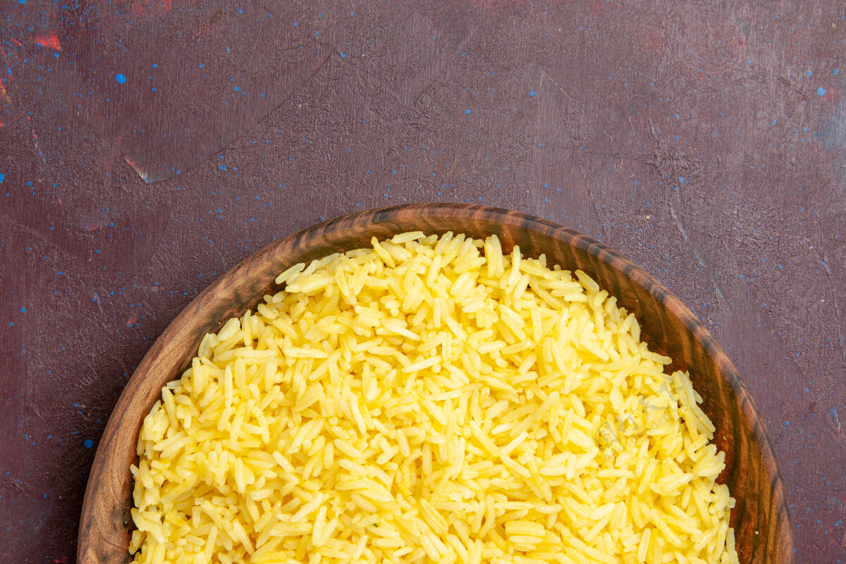 玉米俯瞰美味的米饭在棕色的盘子里在黑暗的桌子上生的顶部种子