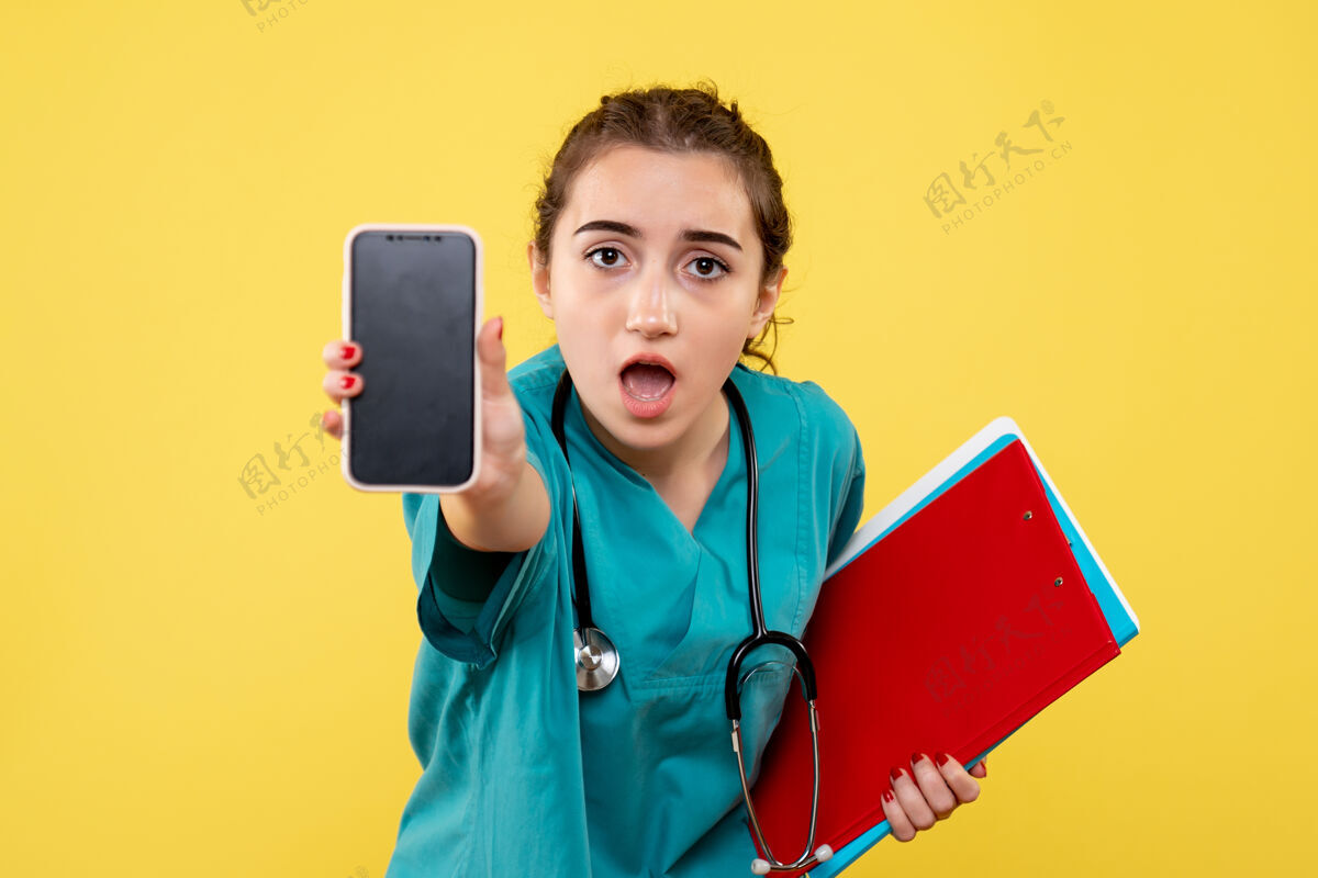 女性正面图女医生穿着医用衬衫 带着便条和电话 健康情绪制服大流行的covid-19病毒黄色情感工作