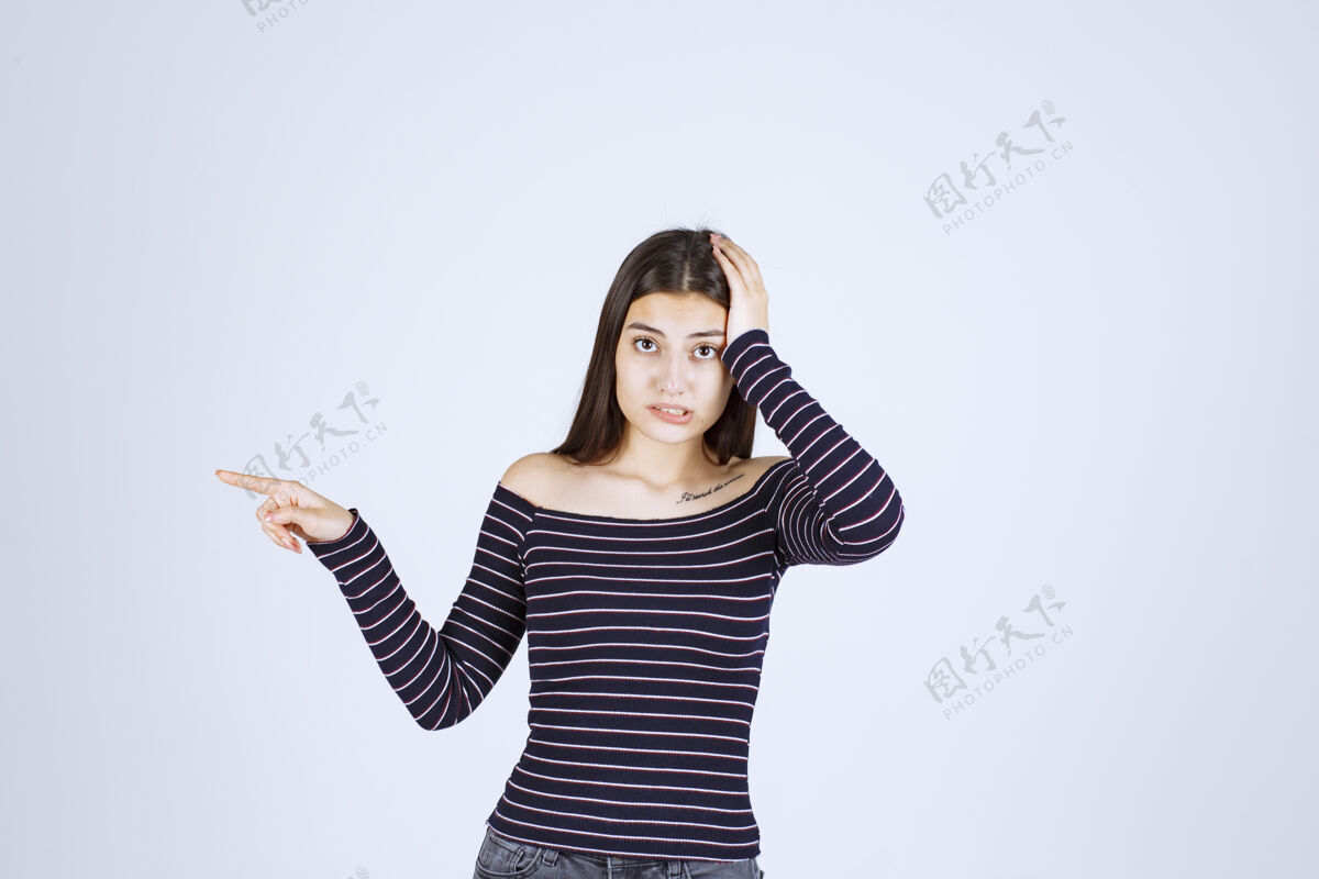 女人穿着条纹衬衫的女孩抱着她的头 因为她筋疲力尽或头痛姿势聪明成人