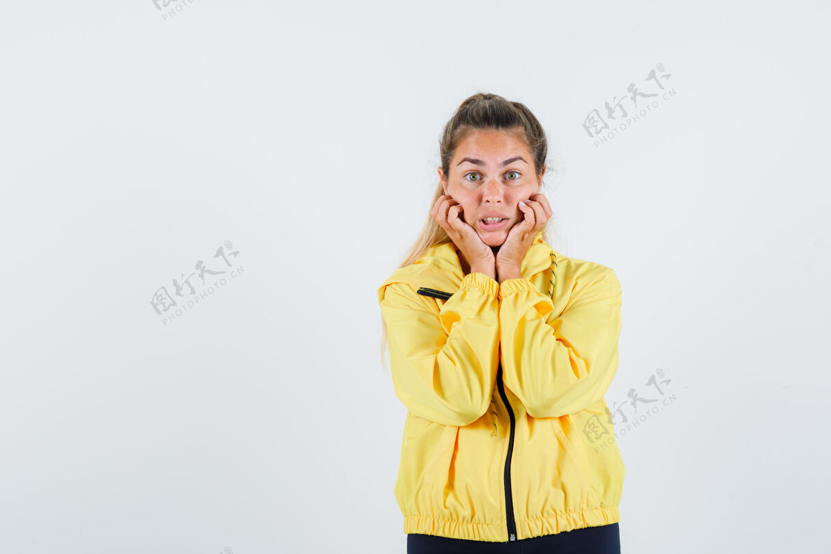 肖像一个穿着黄色雨衣的年轻女人 手放在脸颊上 看起来很不安尼斯女人乐趣