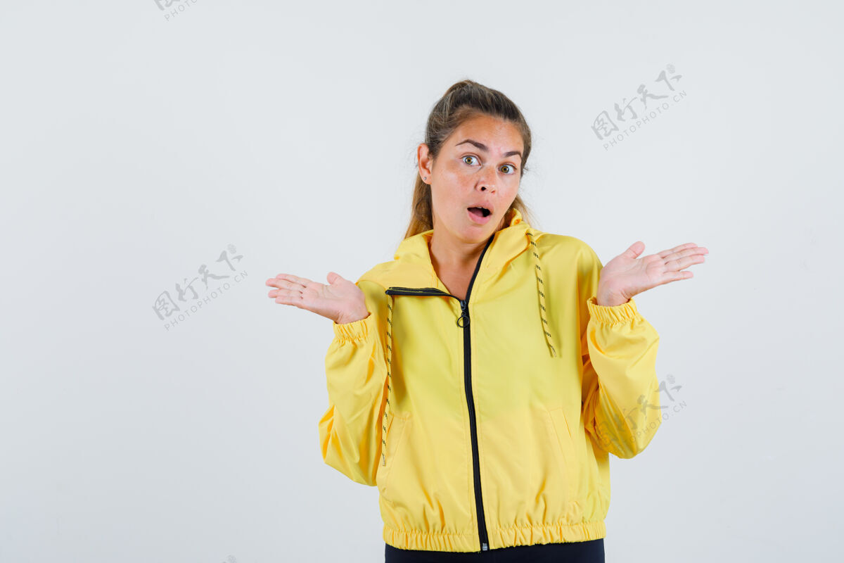 困惑一个穿着黄色雨衣的年轻女子表现出无助的姿态 看起来很困惑爱人休闲