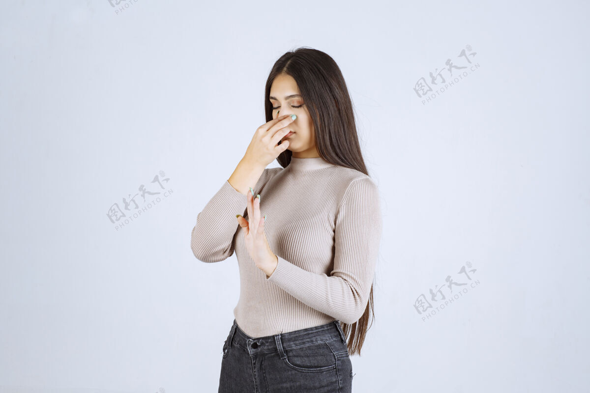 年轻穿灰色毛衣的女孩感觉到难闻的气味 还捂着鼻子成人年轻人雇员