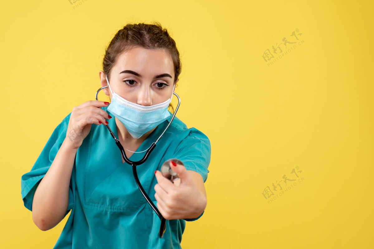 微笑前视图女医生穿着医用衬衫和口罩 带听诊器 病毒颜色一致 情绪covid-19健康女人健康情绪