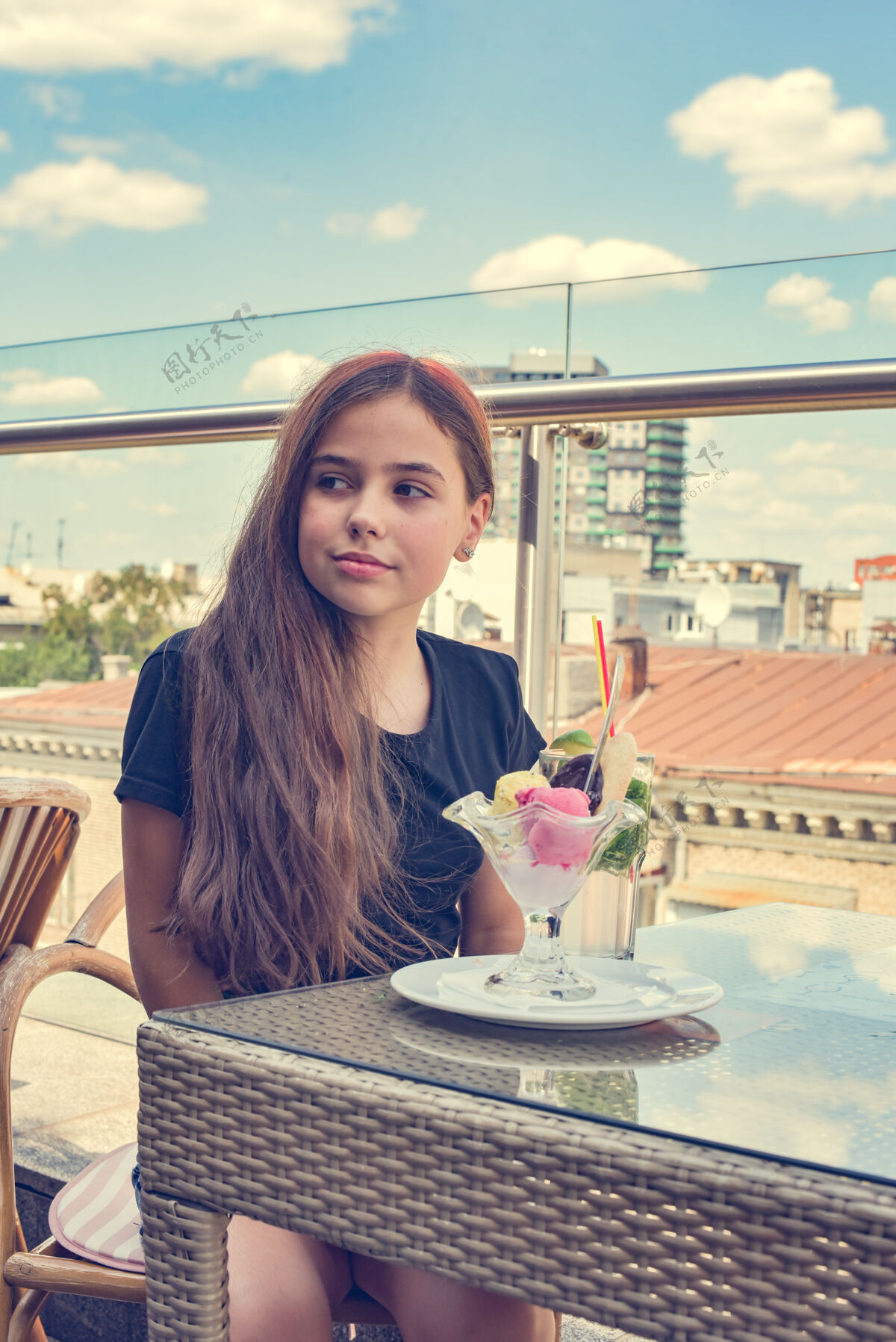 美丽少女开心地微笑着坐在餐厅或咖啡馆吃冰cream.food甜点女孩咖啡厅露台休闲甜点