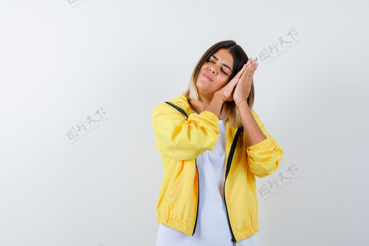 护理年轻女孩穿着白色t恤 黄色夹克 面颊靠在手掌上当枕头 看起来很困倦 俯瞰前方乐趣成人快乐