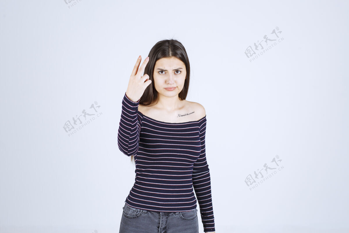 人类穿条纹衬衫的女孩指着脸 流露出感情聪明人服装介绍