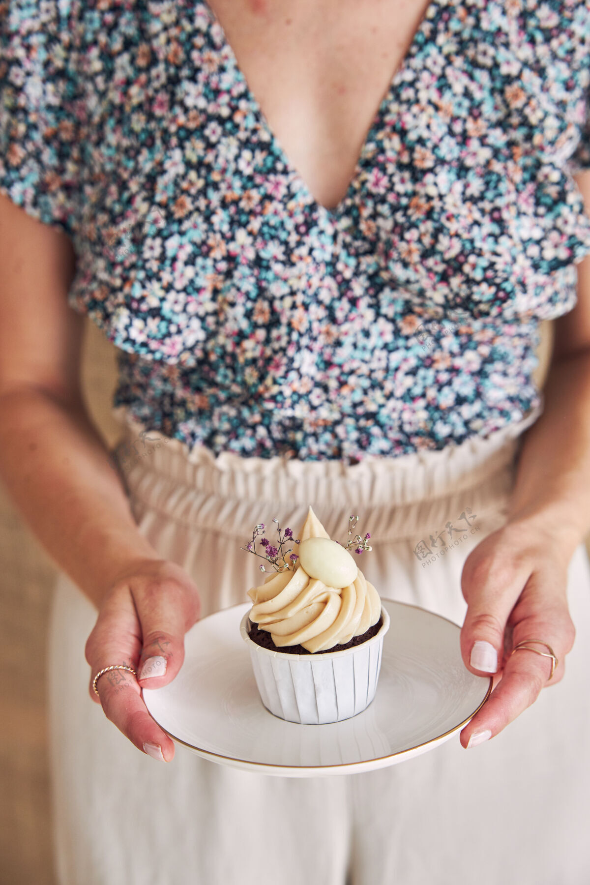 盘子选择性聚焦拍摄一个女人拿着美味的巧克力蛋糕和白色奶油顶巧克力糕点小