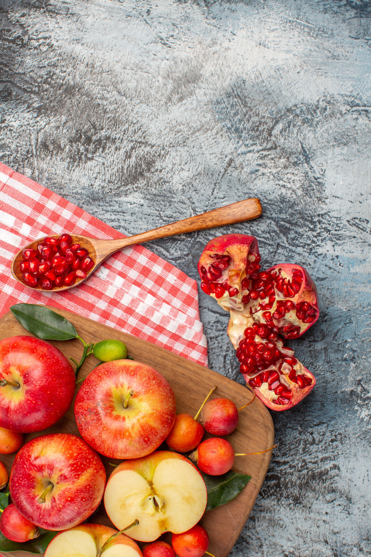 水果俯瞰石榴石榴勺苹果樱桃在桌布板上营养多汁板