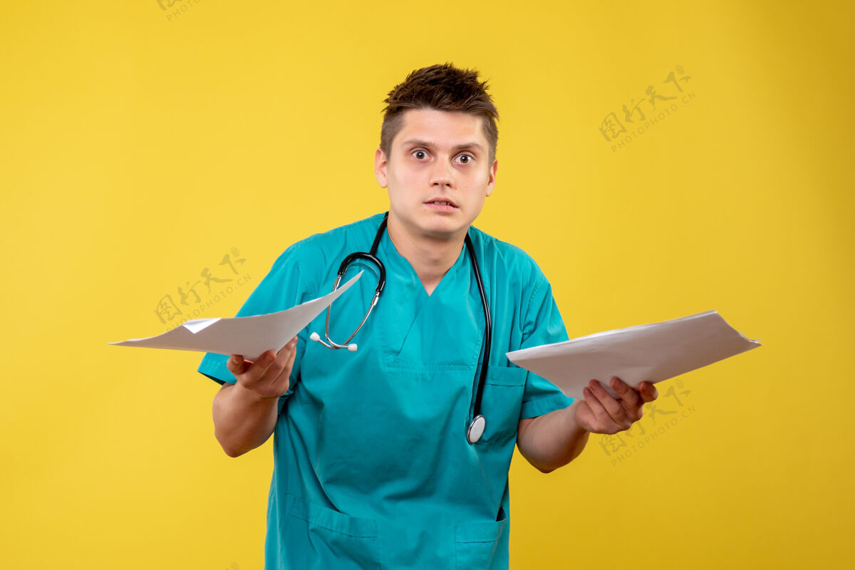 情绪黄色墙壁上的男医生穿着医疗服的正面图正面男医生医院
