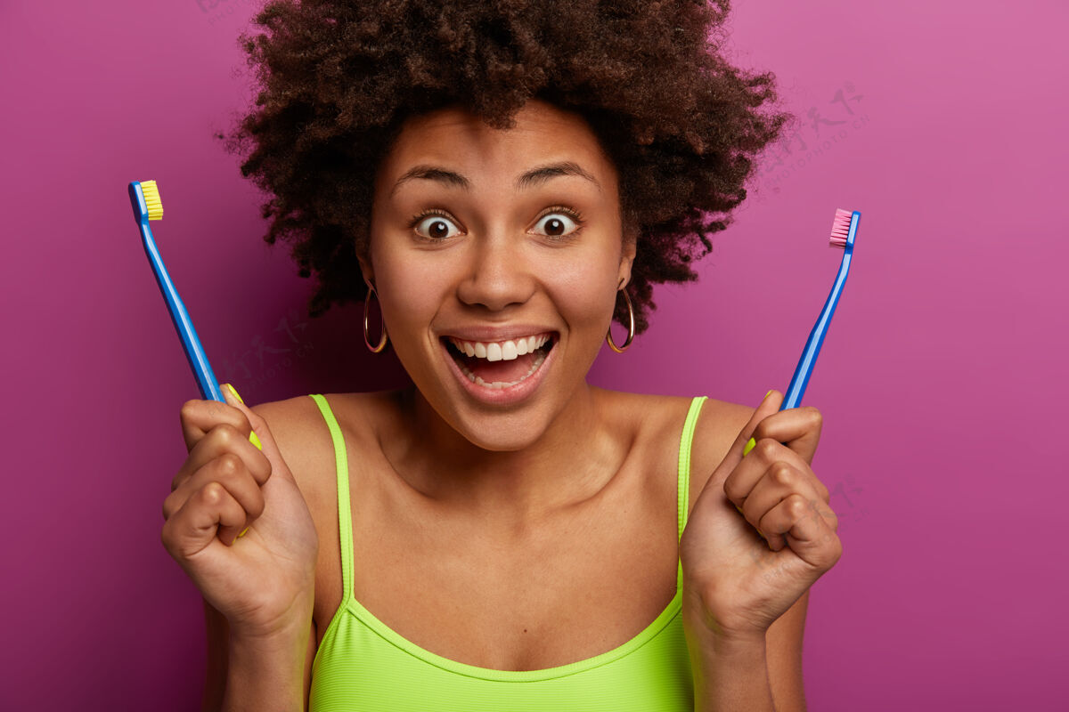 头像特写镜头中快乐的美国黑人妇女拿着两个牙刷新鲜女人女性