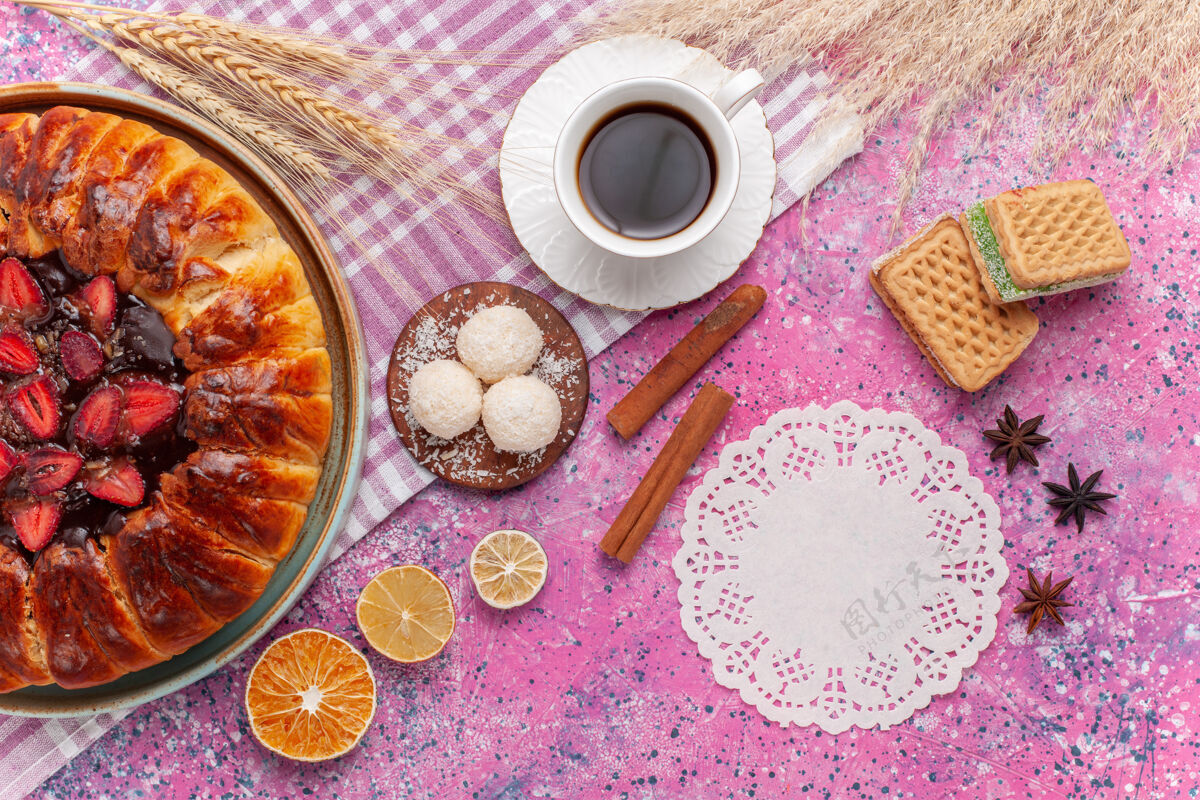 桌子俯瞰美味的草莓派水果蛋糕和一杯粉红色的茶水果食物杯子