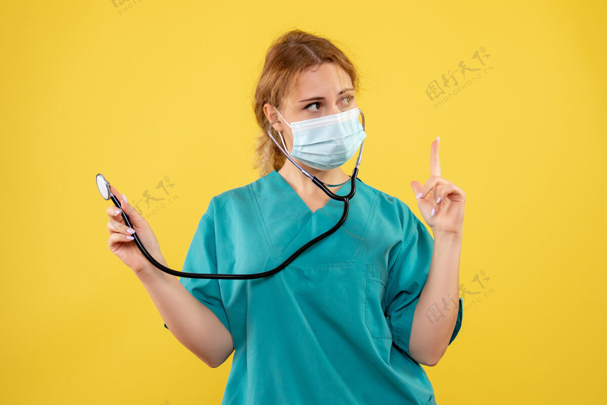 女医生黄墙上穿着医疗服 戴着听诊器面罩的女医生的正面图正面成人人