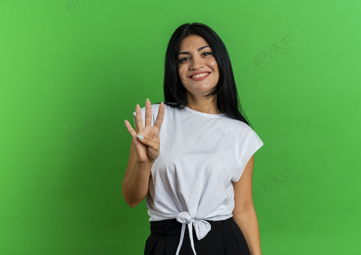女孩微笑的年轻白人女孩用四个手指做手势空间微笑绿色