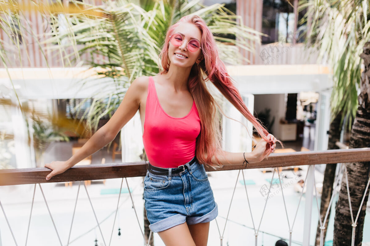 年轻时尚感性的女人在夏天玩她的粉红色长发女人休息游客