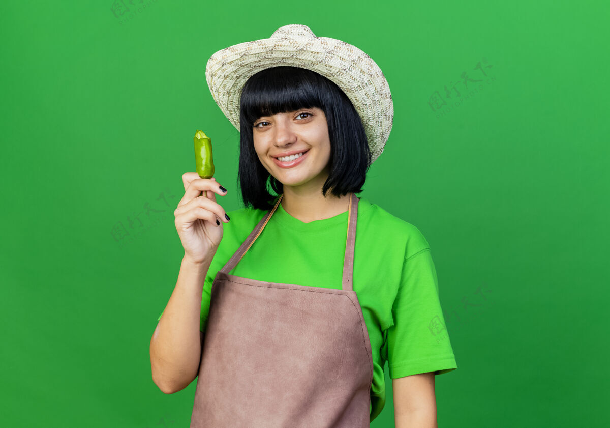 花椒身着制服的年轻女园丁微笑着戴着园艺帽 手里拿着碎胡椒微笑空间女性