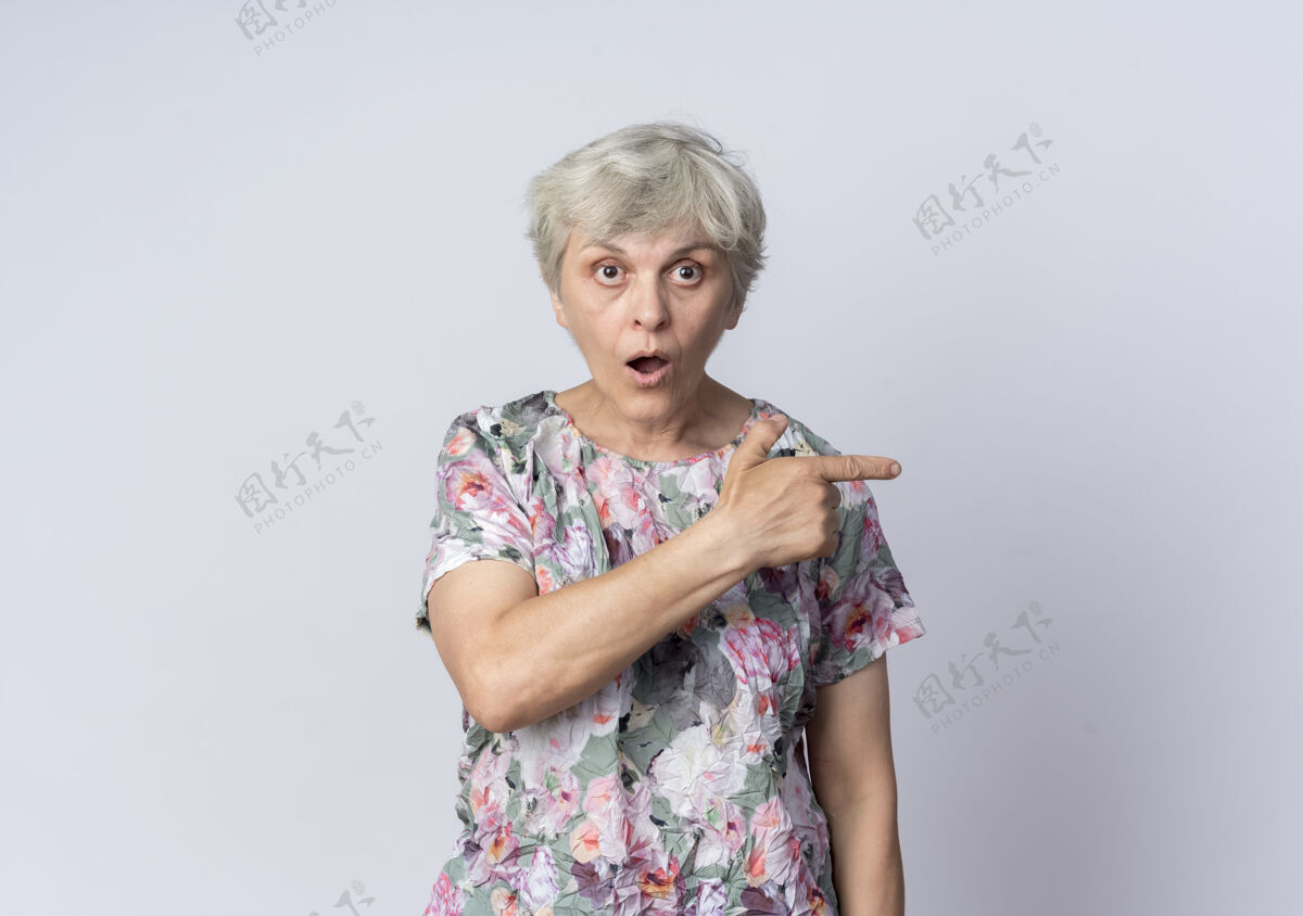 老的惊呆了的老妇人指着旁边的白墙上孤零零地向前看女人侧线老的