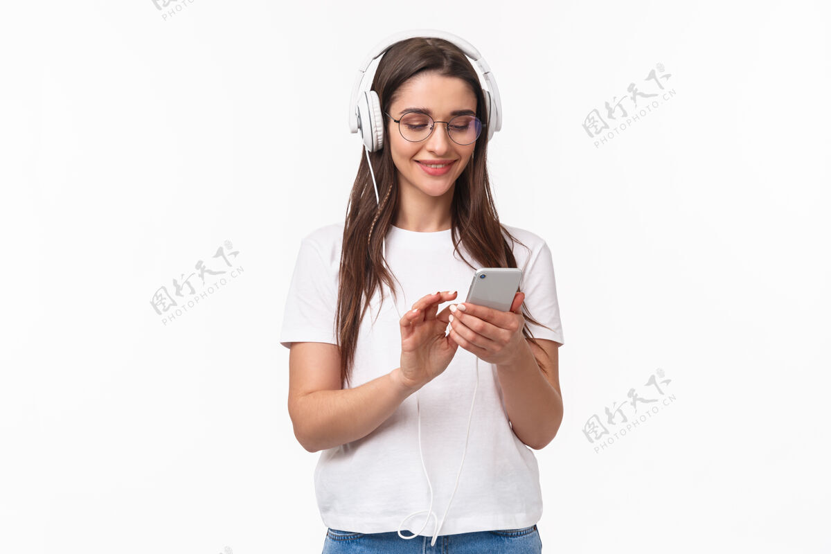 商业一位富有表现力的年轻女子手持手机聆听音乐学生美丽美丽
