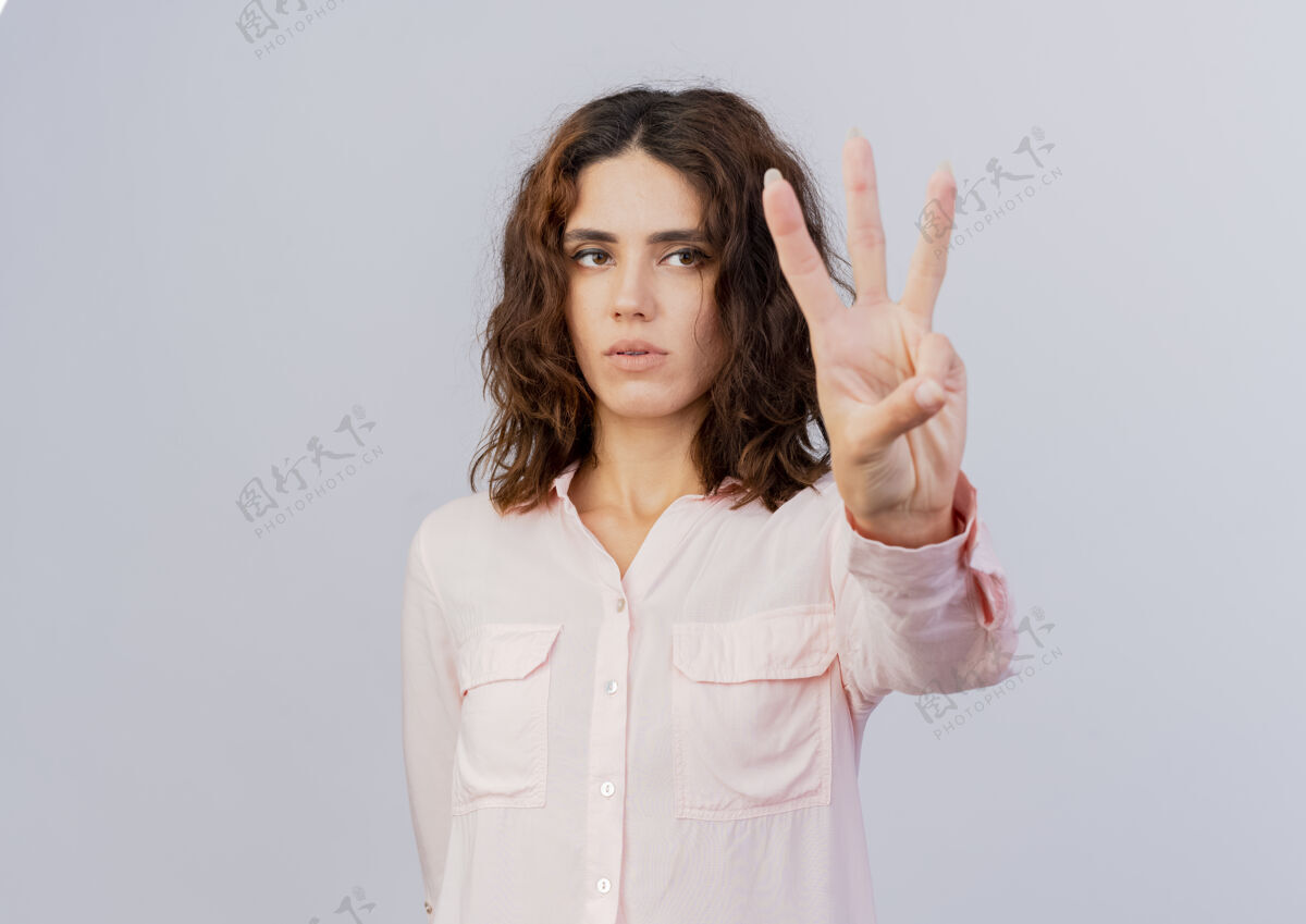 手指自信的年轻白人女孩用三个手指做手势女孩空间自信