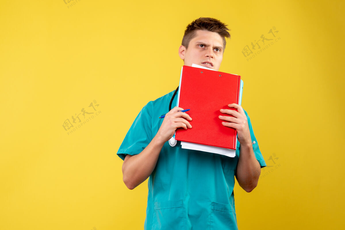 情绪黄色墙壁上的男医生穿着医疗服的正面图前面男医生健康