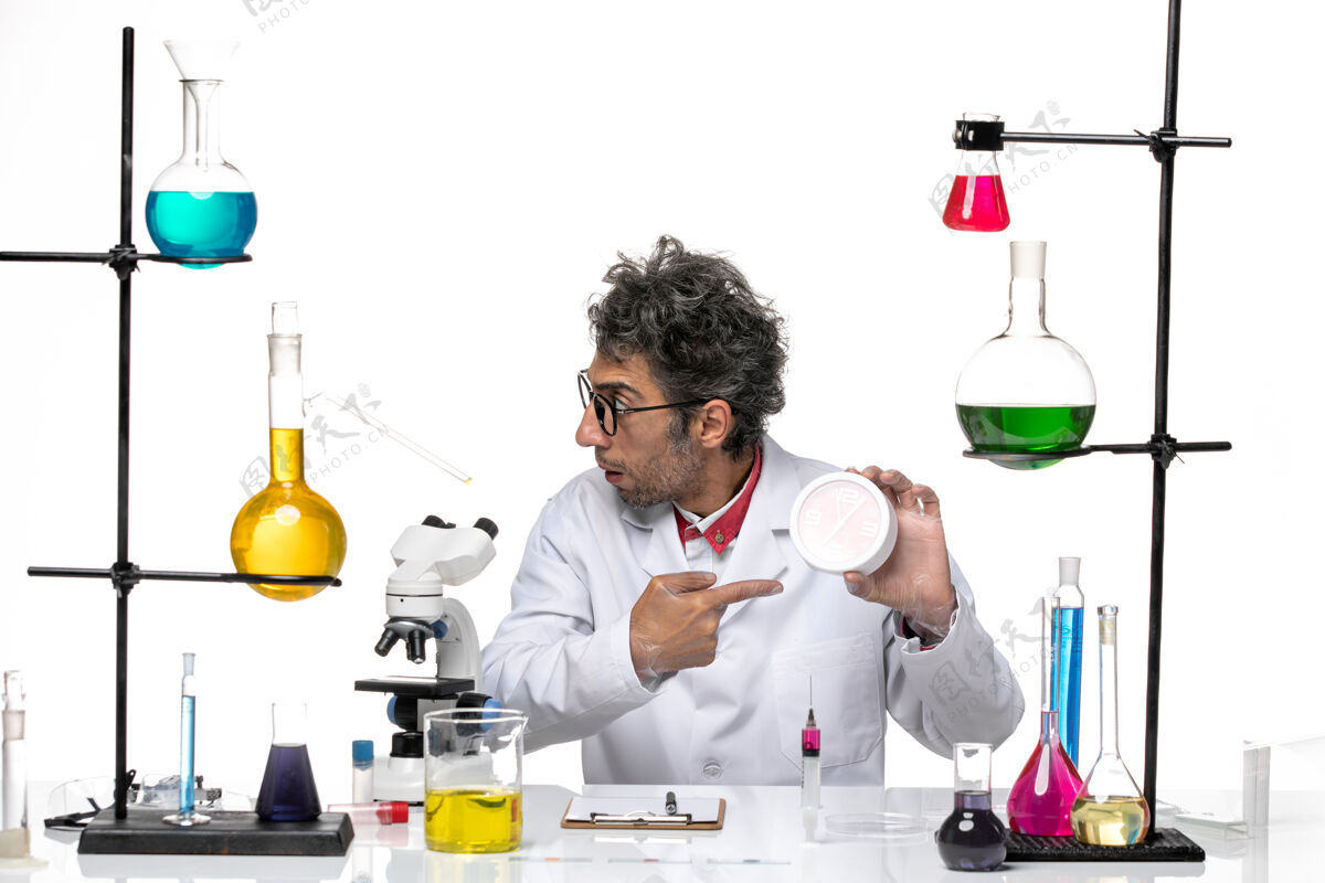 工具前视图身穿医疗服的男科学家手持白色背景上的红色时钟化学冠状病毒实验室健康医生时钟保持
