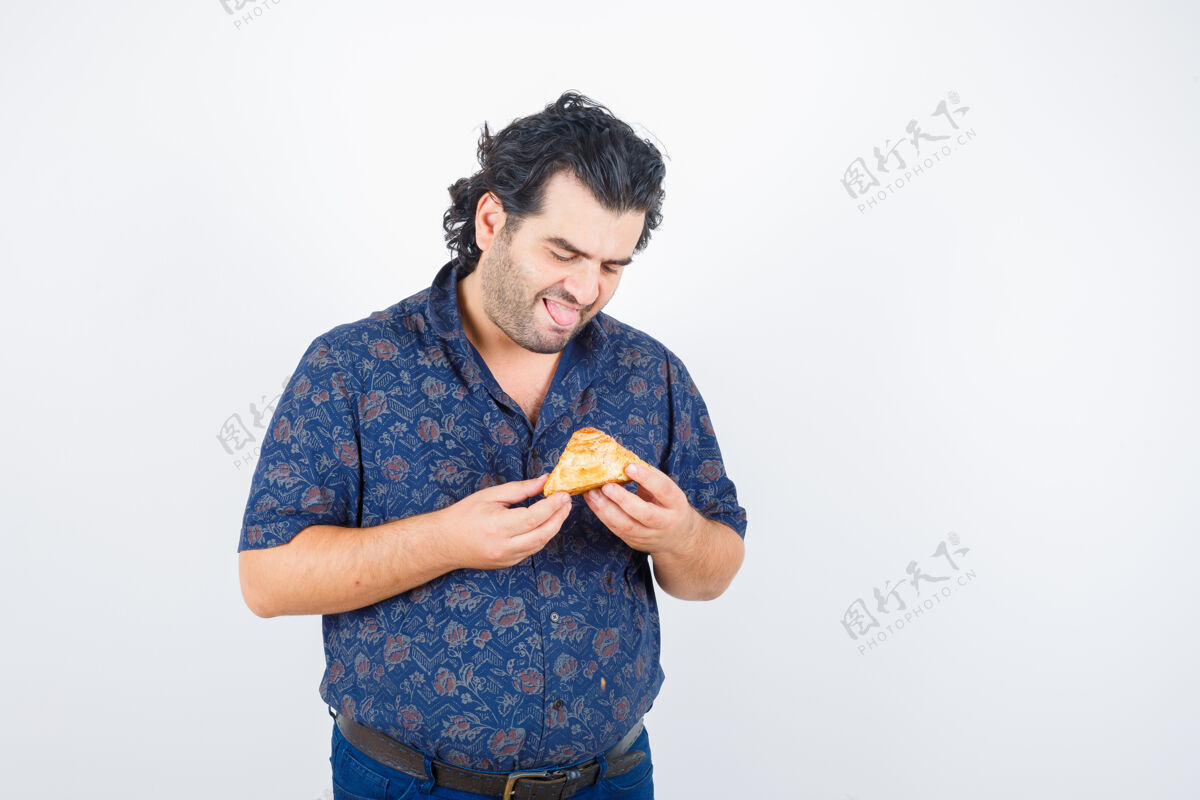 健康成熟的男人看着衬衫里的糕点产品 看起来很开心 前视微笑成人肖像