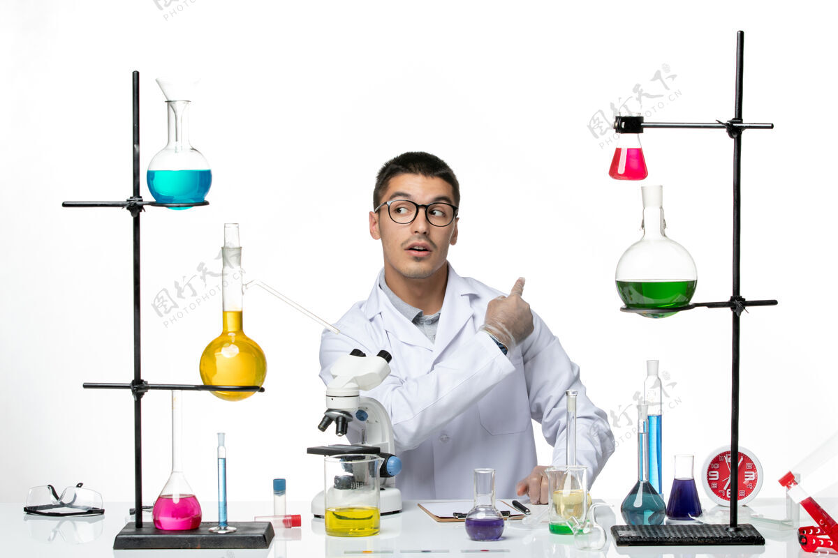 病毒正面图：穿着白色医疗服的男性化学家坐在白色办公桌上 拿着解决方案病毒实验室共患疾病科学医生烧杯实验室