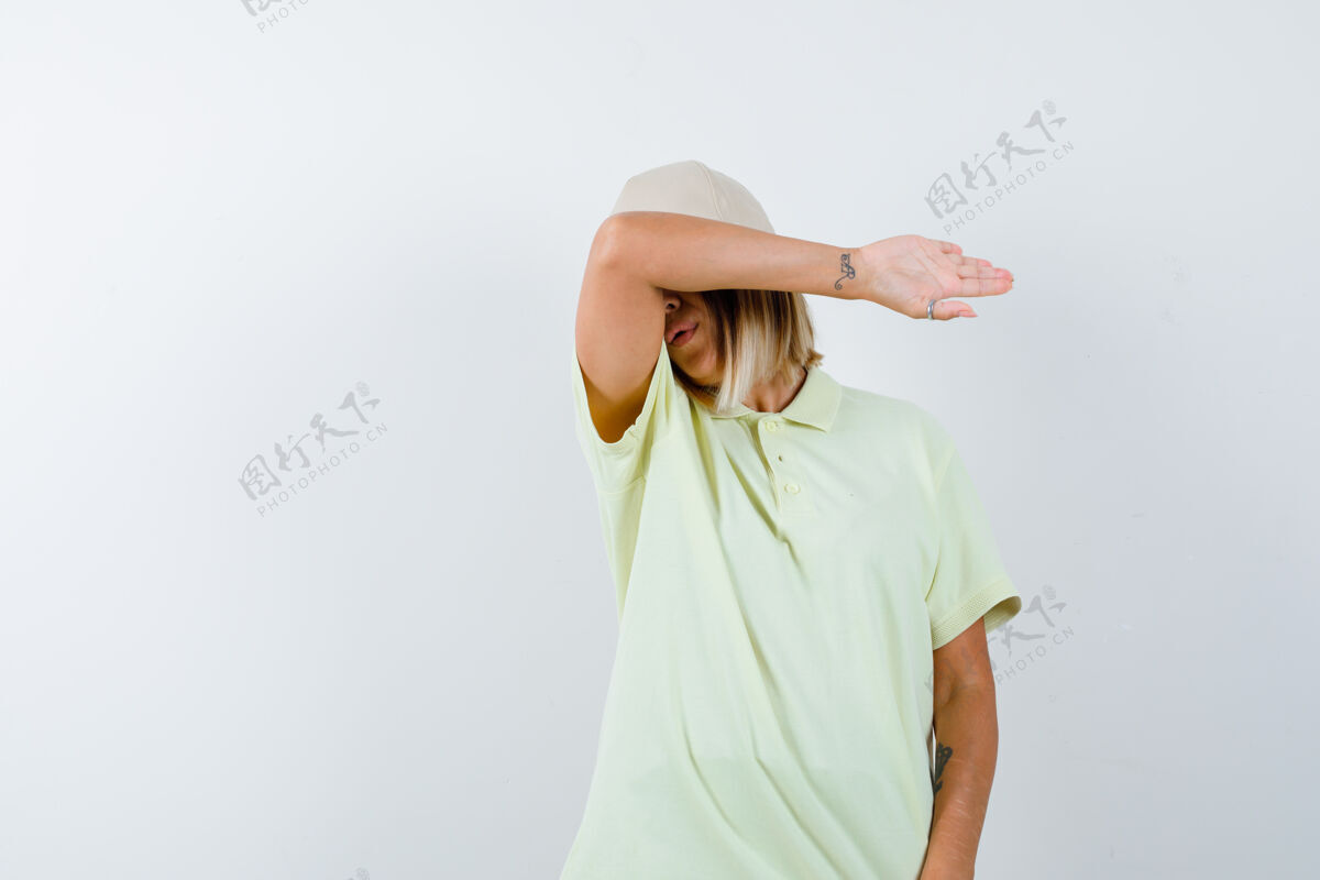 帽子一位年轻女士穿着t恤 戴着帽子 额头枕在胳膊肘上 看上去很疲惫漂亮前额深色