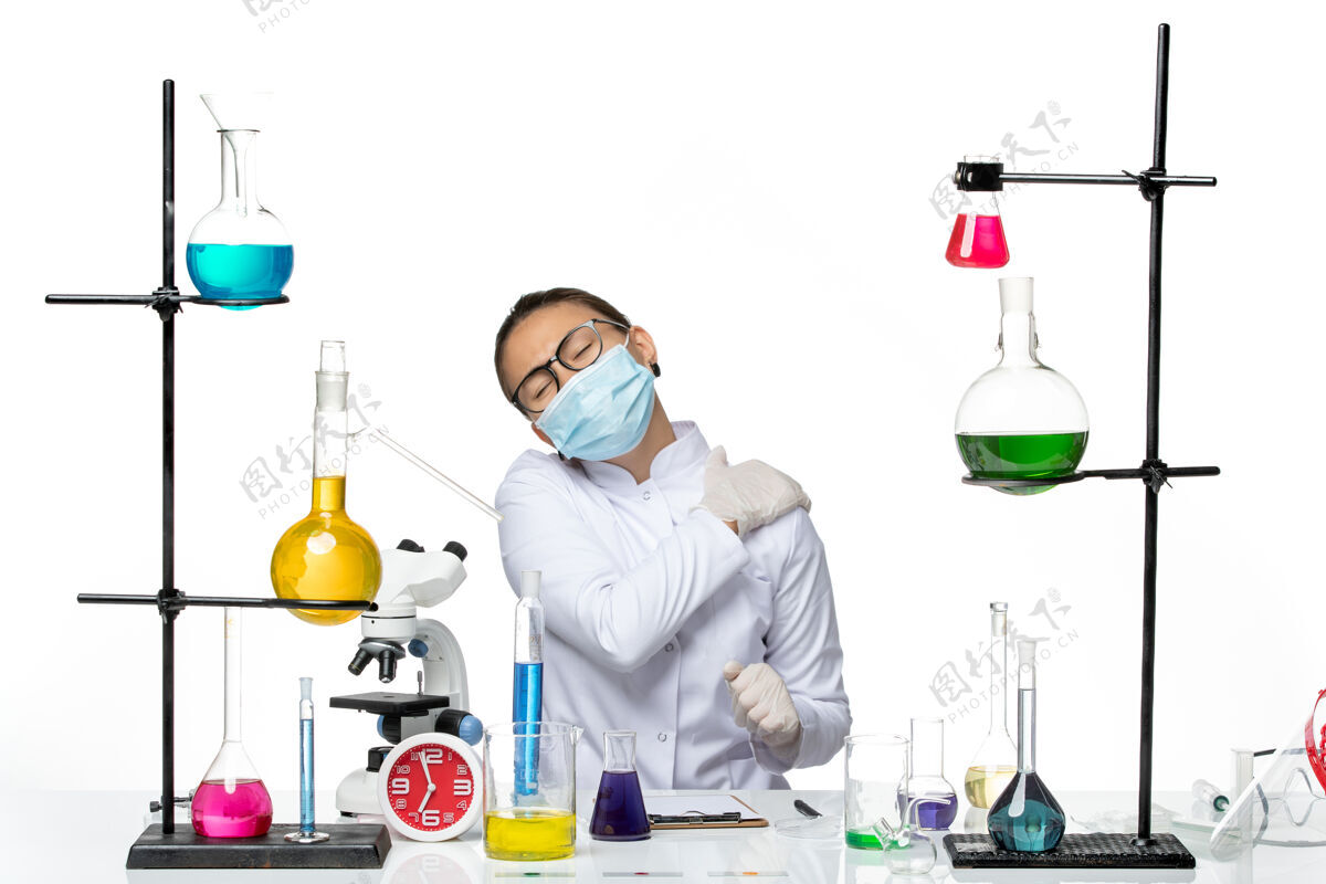 实验前视图穿着医疗服的女化学家戴着口罩在白色背景上疼痛病毒化学实验室病毒飞溅套装化学药品