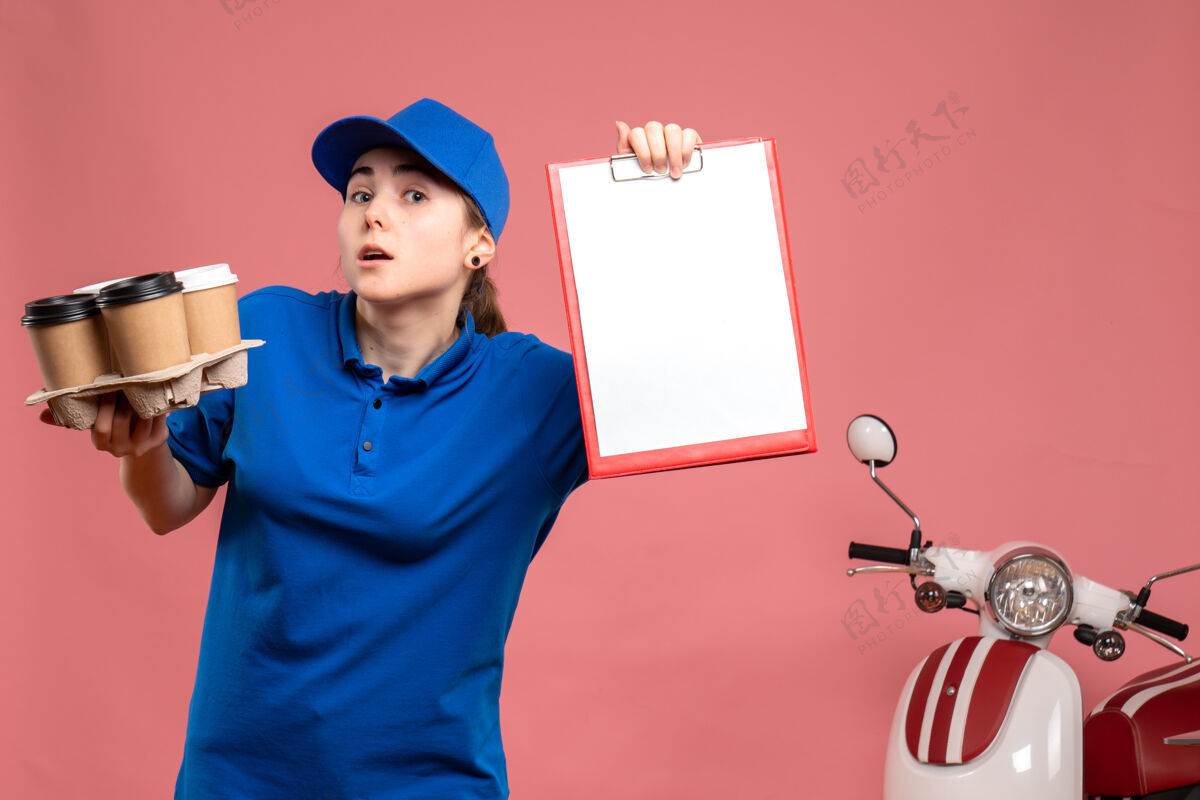 专业正面图：女快递员 带着咖啡和文件 粉红色的便条 工作 送货 工作 自行车 制服 服务人员便条微笑工作