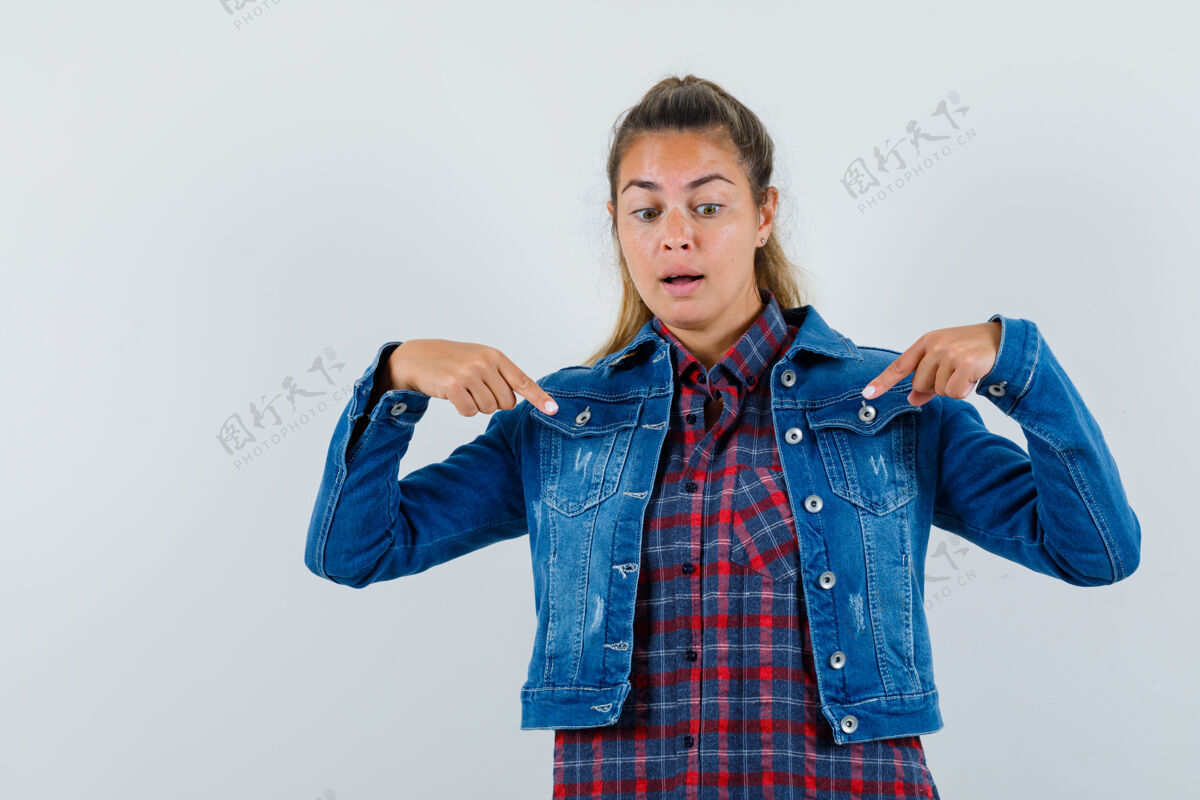指向年轻女子指着衬衫 夹克衫 看着重点前视图肖像女人视图
