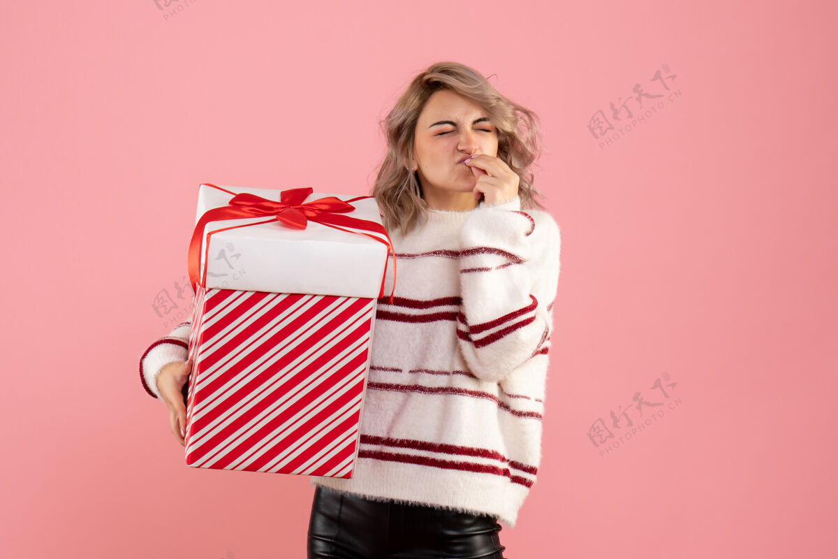 年轻女性前视图年轻女性与圣诞节礼物人女人粉色