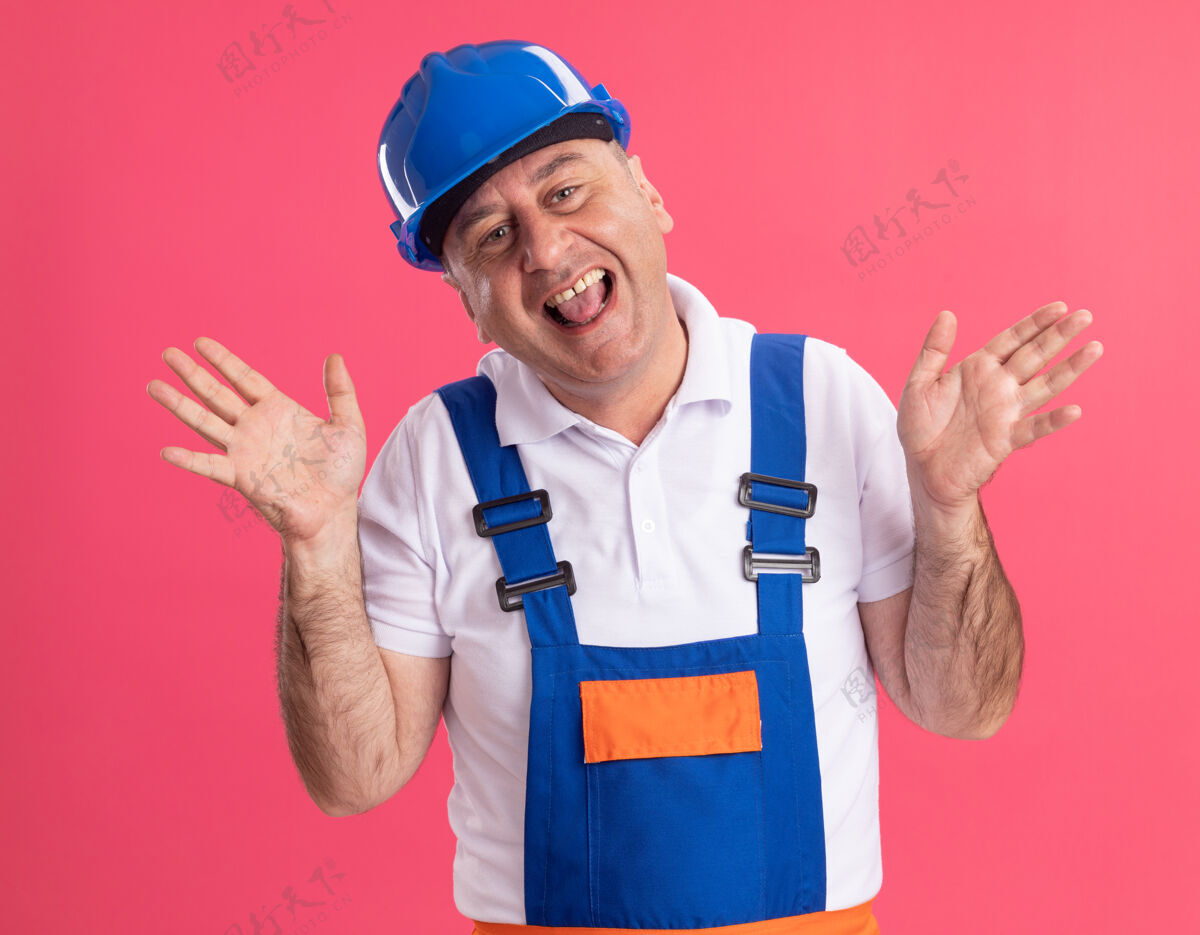 人快乐的成年白人建设者身穿制服站在粉红色的举手人高兴制服