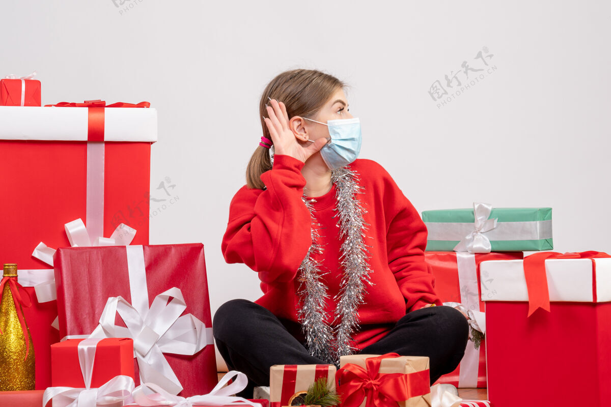 年轻女性正面图年轻女性戴着面具围坐在圣诞礼物旁礼物年份圣诞节