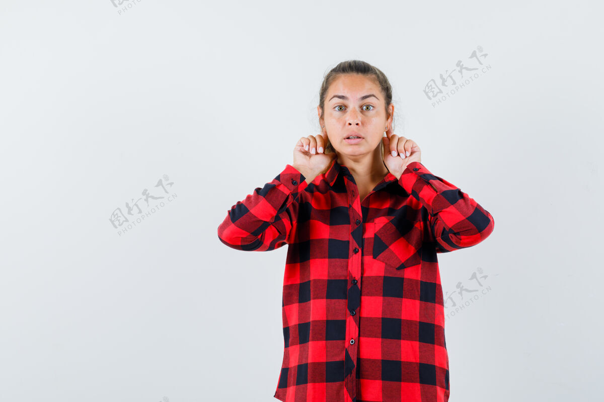 耳朵穿着休闲衬衫的年轻女士把手指放在耳朵后面 看起来很好奇年轻人肖像休闲