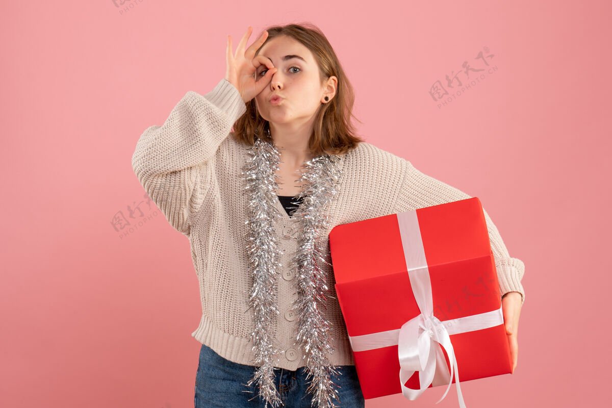 圣诞节正面图年轻女性手持圣诞礼物女人开衫衣服