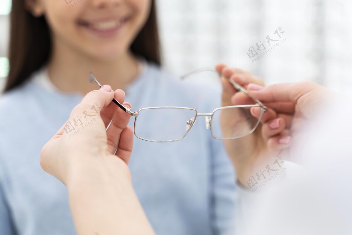 员工员工帮女孩试眼镜试穿视力室内