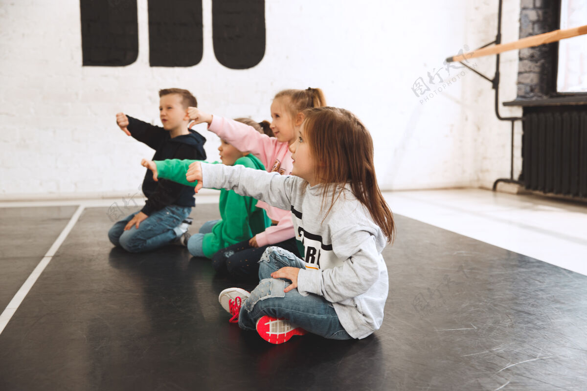 积极孩子们坐在舞蹈学校芭蕾 嘻哈 街头 时髦和现代舞者的概念孩子运动运动