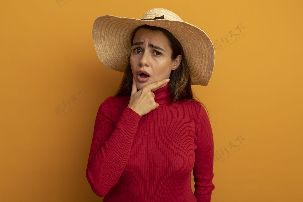 年轻一个戴着沙滩帽的愚蠢漂亮的白人女人把下巴托在橘子上漂亮帽子女人