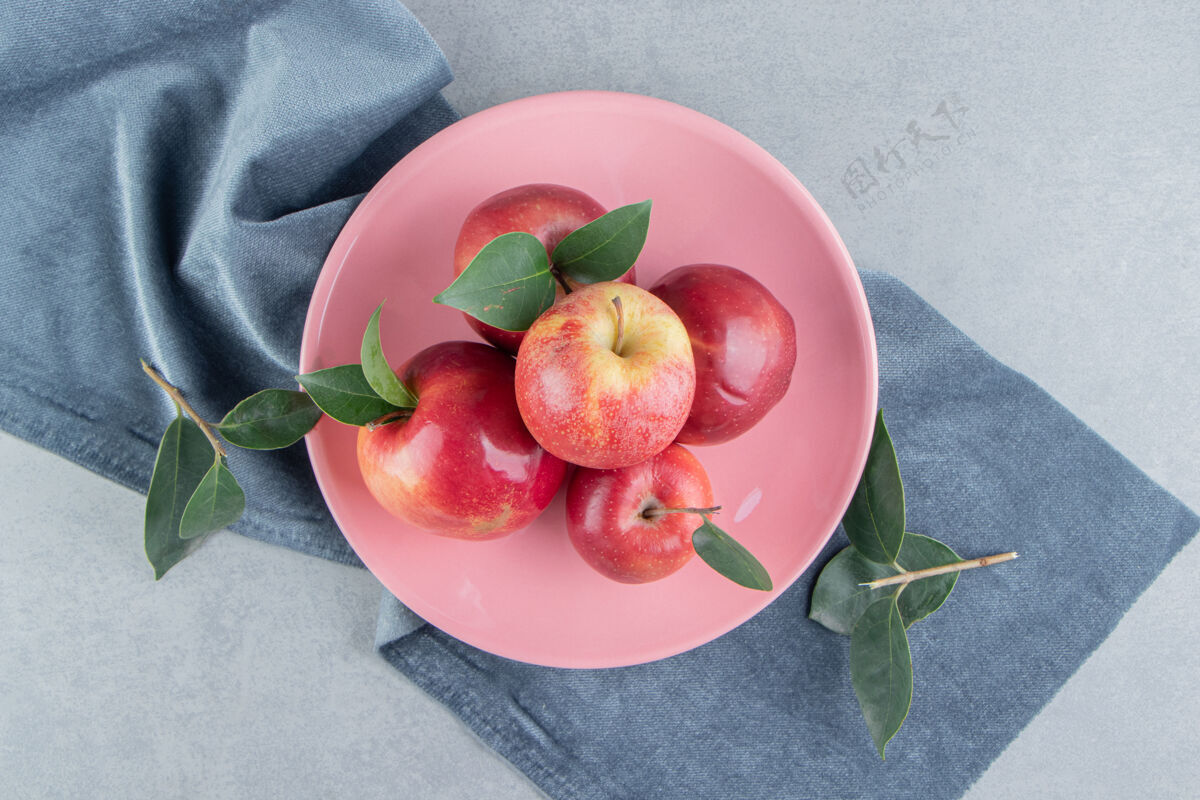 健康在大理石上的一块布料上的盘子上放着一小堆苹果风味水果苹果