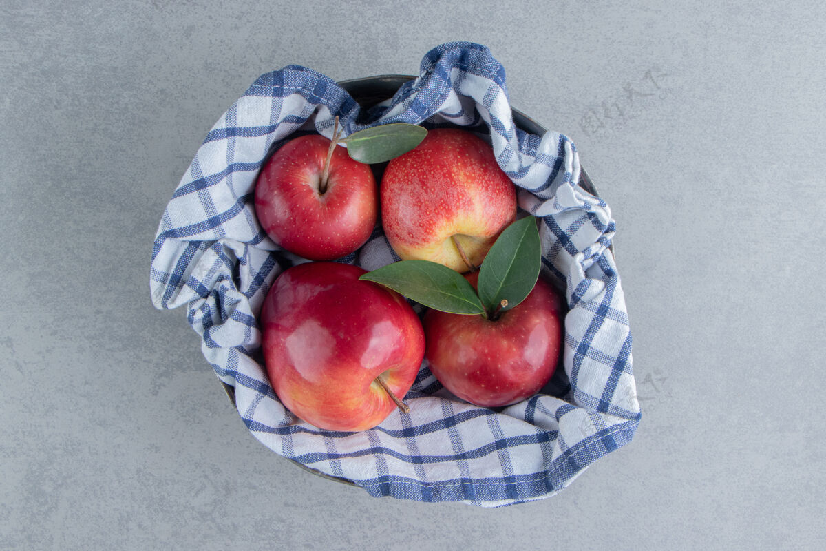 有机用毛巾把苹果包在大理石上新鲜多汁水果
