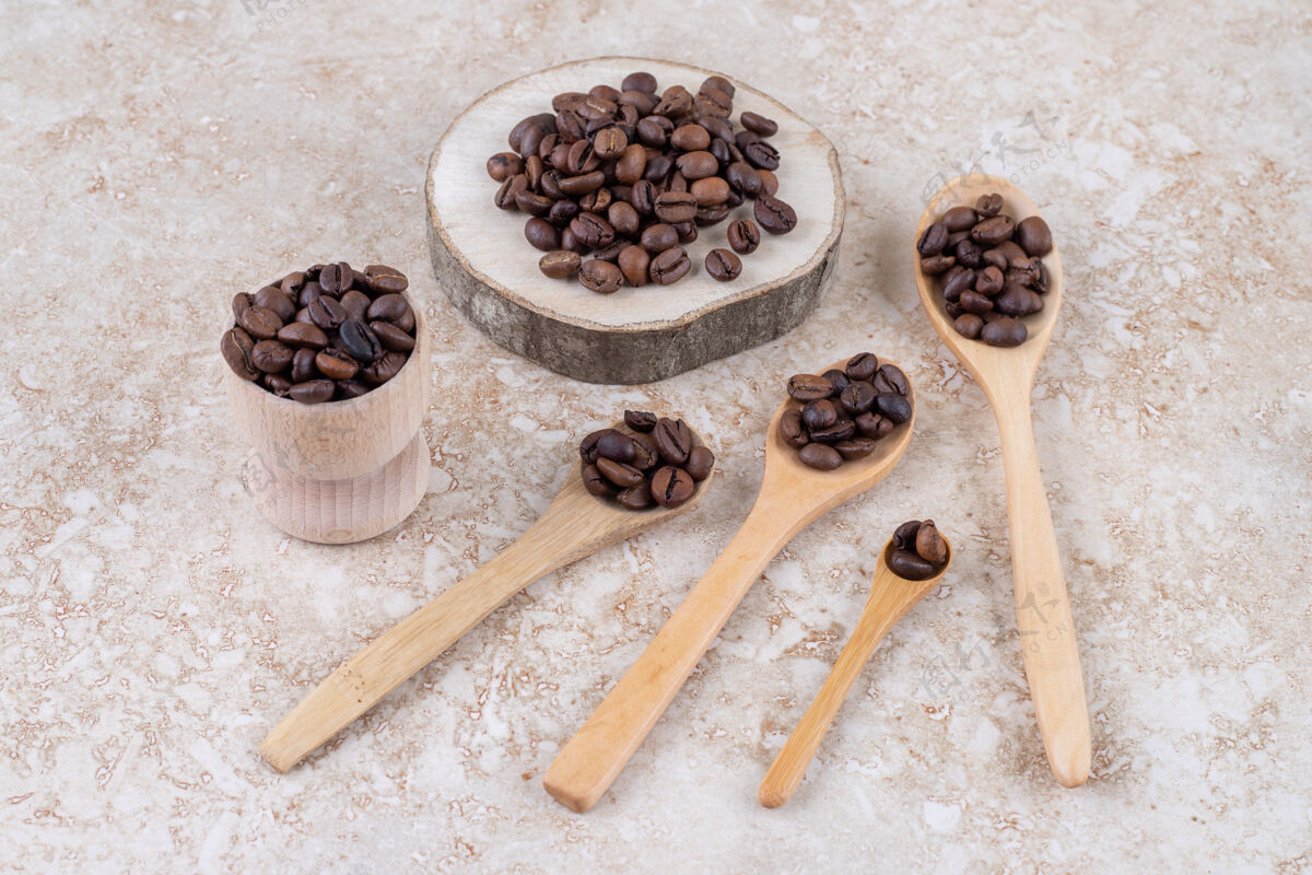 勺子咖啡豆放在勺子上 一块木头和一个小杯杯子芳香木头