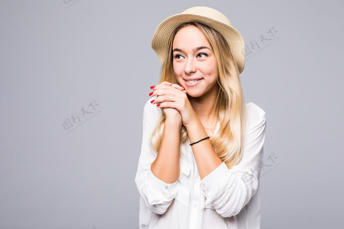 表情一个戴着帽子的微笑的年轻女子的特写肖像 远远地看着隔着灰墙的复制品空间爱情女孩女性