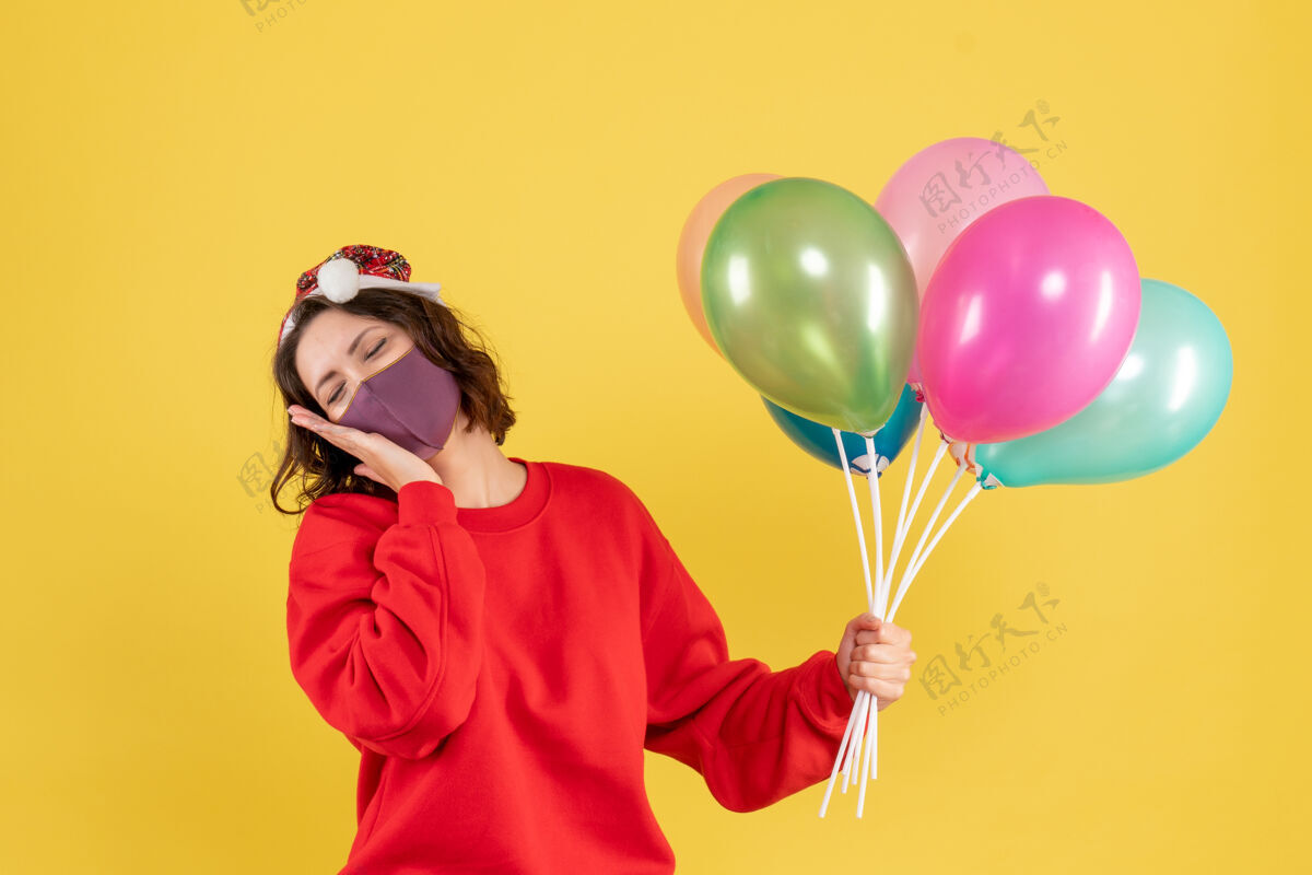 氧气正面图年轻女性手持气球 戴着黄色的无菌面具风景吹庆祝