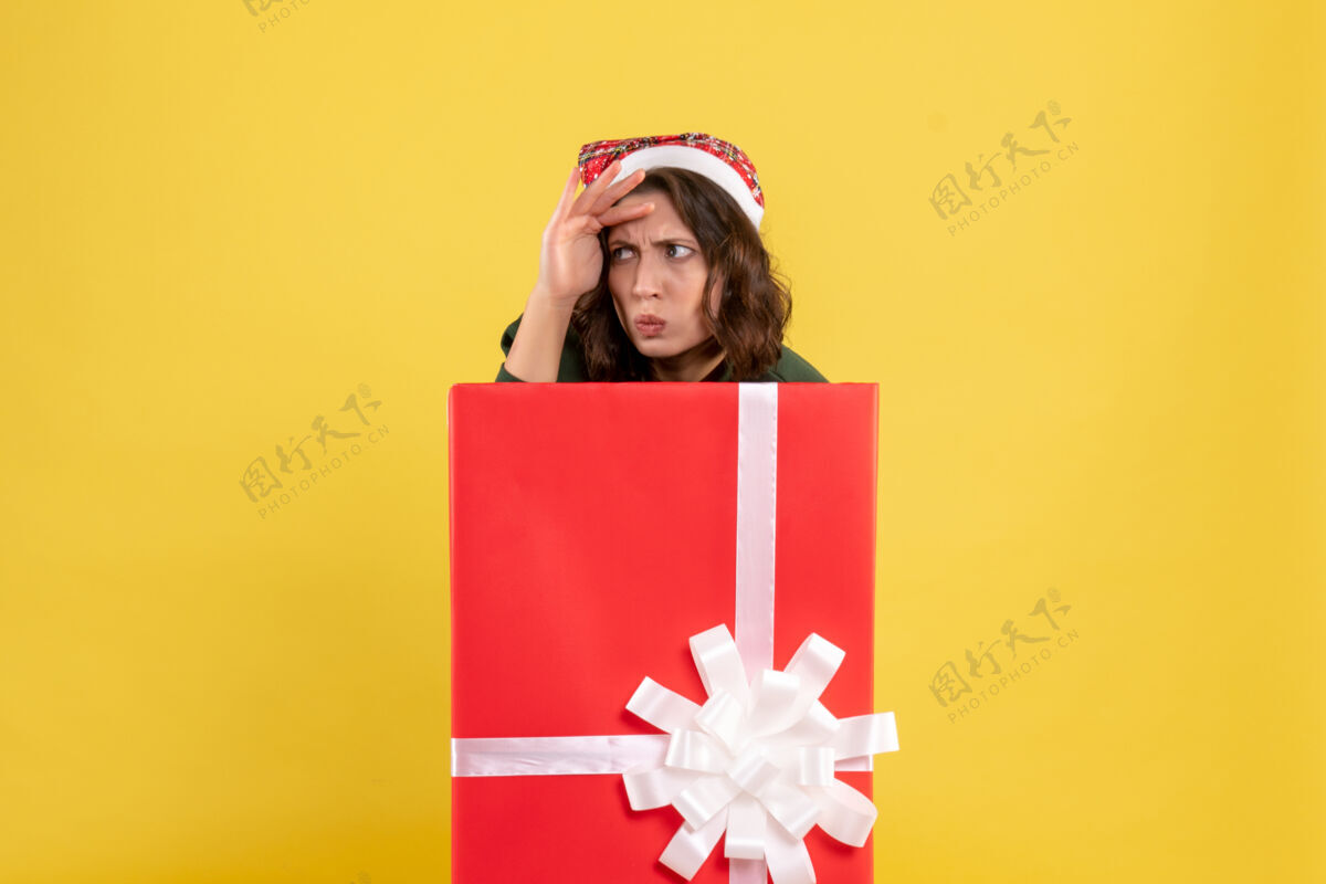 购物前视图年轻女性躲在黄色盒子里里面圣诞节隐藏