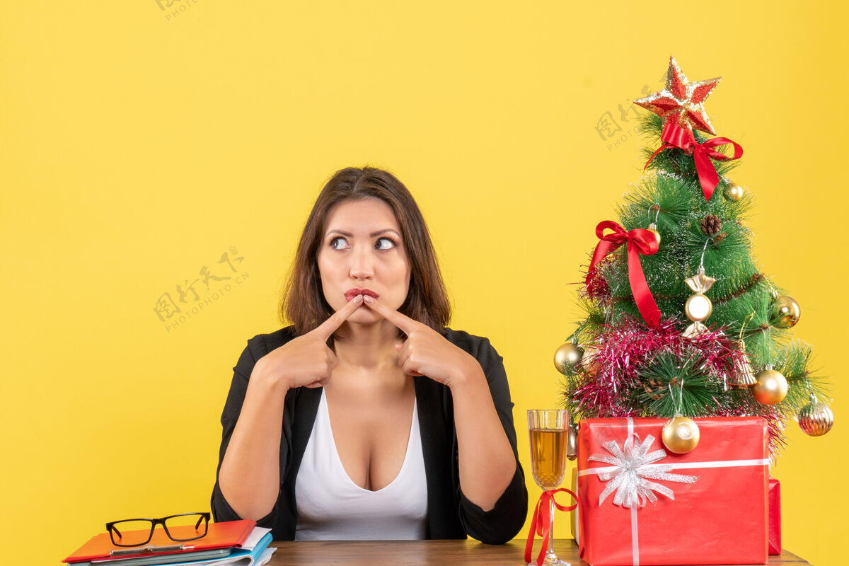 东西Xsmas心情与年轻严肃的商务女士专注于某件事坐在黄色的办公室年轻女士黄色